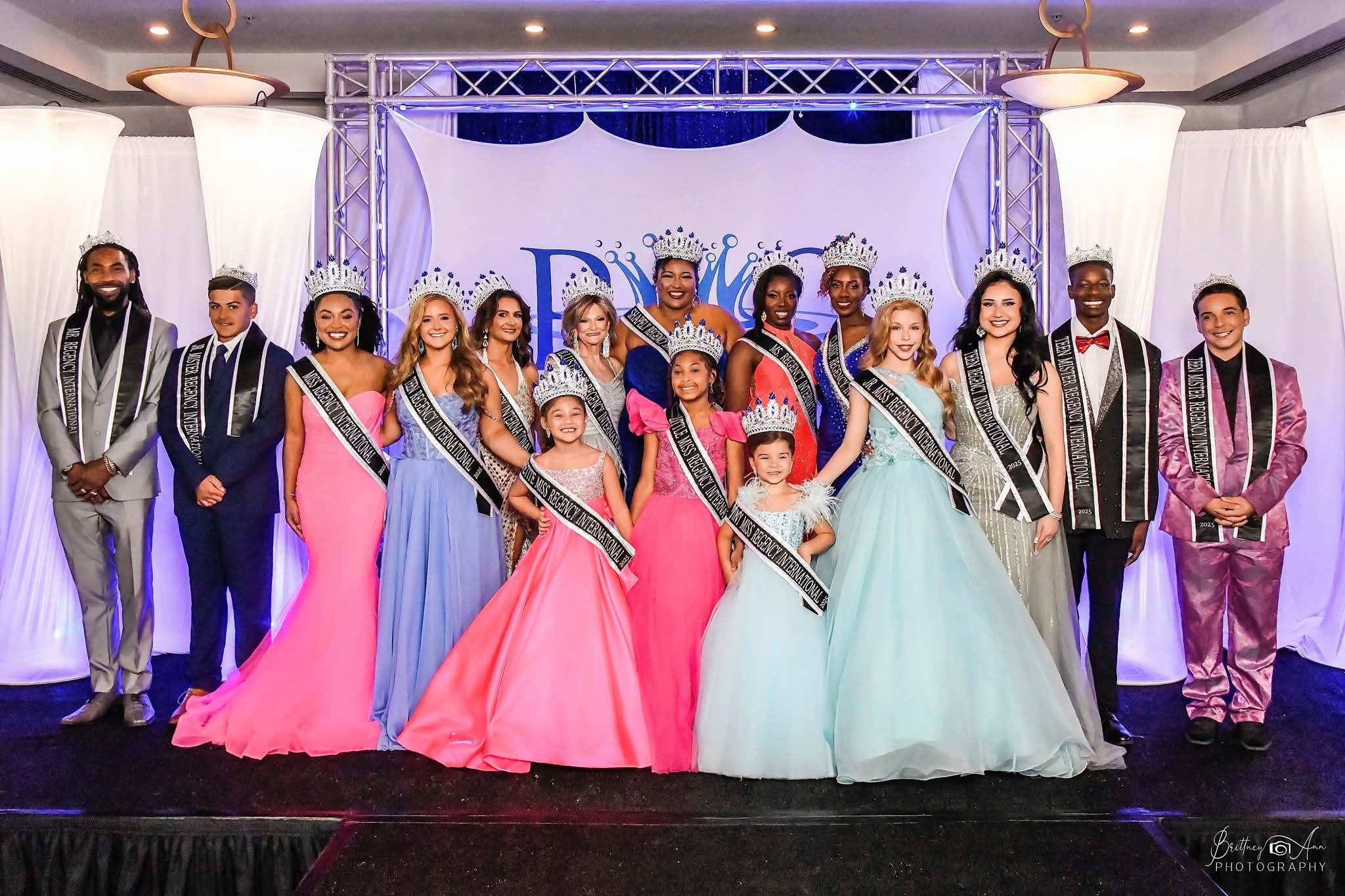 Group photo of the Regency International Pageant 2025 winners wearing crowns, sashes, and gowns during the official crowning ceremony.